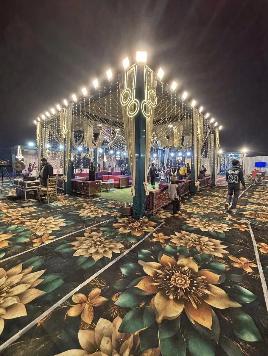 Lounge pavilion tent with sofa seating, fabric drapes and string lights at night by Raju Tent & Catering Services, Bilaspur